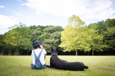 Parkta köpeği olan küçük kız. 