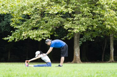 Genç Asyalı çift parkta egzersiz yapıyor.