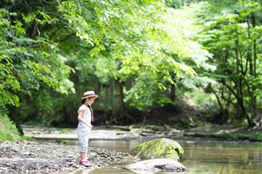Parktaki nehirde oynayan tatlı kız. 