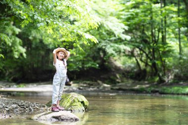 Parktaki nehirde oynayan tatlı kız. 