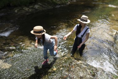 Anne ve çocuk nehirde oynarken