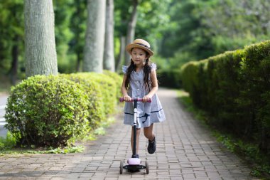 küçük kız parkta scooter üzerinde 