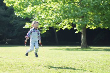 Parkta ip atlayan küçük kız.