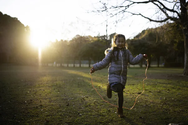 girl with jumping rope in autumn park
