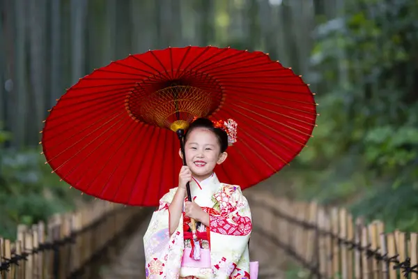 Stock image asian girl in  traditional japanese dress with umbrella in park 