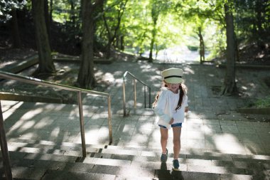 Park merdivenlerinde yürüyen küçük kız.