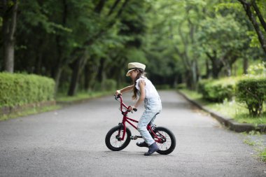 Parkta bisiklet süren Asyalı kız. 