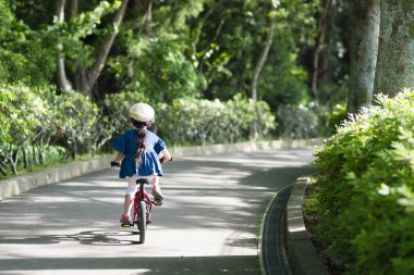 Parkta bisiklet süren Asyalı kız. 