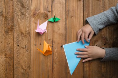 Origamiyi katlamak için çocuk elleri