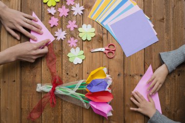 Ebeveyn ve çocuk elleri origami ile oynuyor