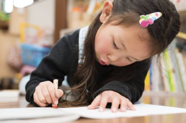 Asyalı kız evde çizim yapıyor.