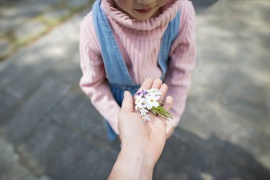 Ebeveyn ve çocuk elleri Çiçek dağıtıyor