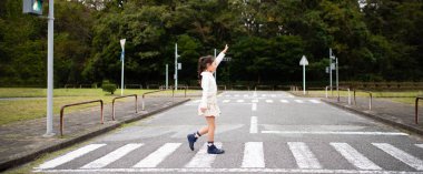 Çocuk yaya geçidini geçiyor.