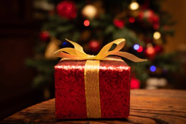 Tahta arka planda bir hediye kutusunda noel ağacı 