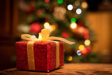 Tahta arka planda bir hediye kutusunda noel ağacı 