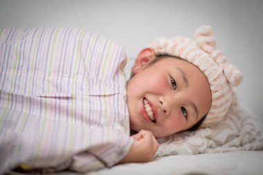 Asyalı küçük kız yatakta uyuyor.