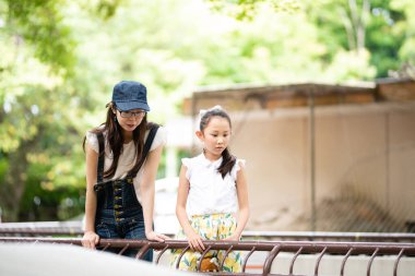 Ebeveynler ve çocuklar hayvanat bahçesinde eğleniyorlar. 