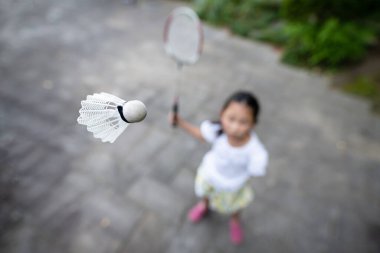 Sahada badminton oynayan kız.