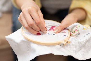 Nakış işleyen bir kadının elleri.