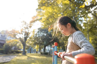 Parkta oyun parkında oynayan küçük tatlı Asyalı kız.
