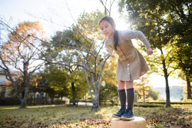 sonbahar parkta oynayan kız