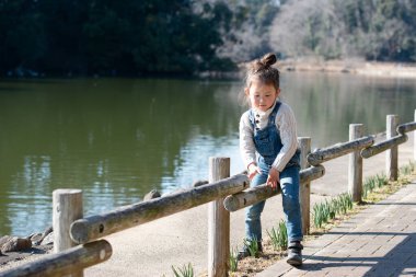 Kız gölün kenarında oynuyor.