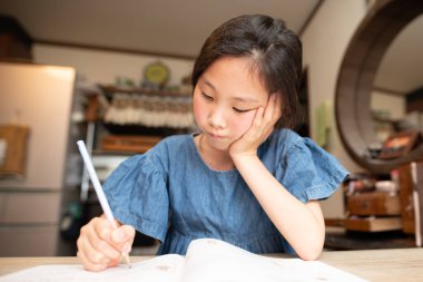 Asyalı kız ödevini evde yapıyor