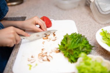 Anne ve kızı evde salata yapıyor.