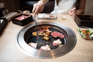 Japon Yakiniku restoranında yemek yiyen bir kadın.