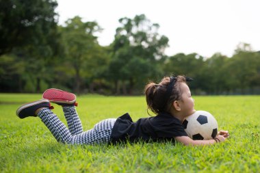 Bahçesinde top oynayan küçük bir kız. 