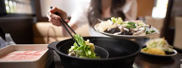 Shabu shabu yiyen bir kadın.