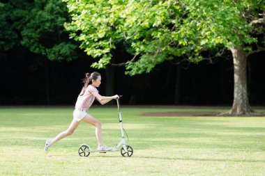 Tekme scooterda oynayan kız