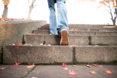 Düşen yapraklar park merdivenleri ve kadın ayakları