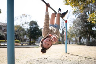 Parkta oyun parkında oynayan küçük tatlı Asyalı kız.