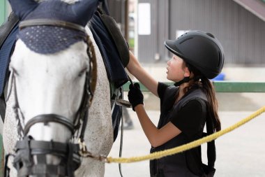 Atla ilgilenen çocuk.