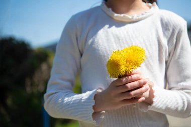 Bir sürü sarı çiçeği olan bir çocuk