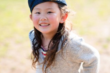 Çimlerde gülümseyen kız