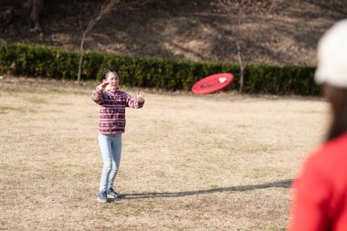 Anne ve kızı uçan diskle oynuyorlar.