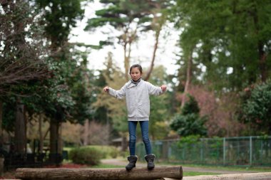 Kız bahar parkında oynuyor.