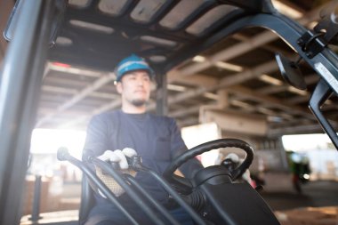 Erkek eller forklift manevrası yapıyor.