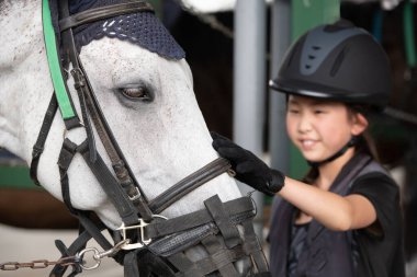Atla ilgilenen çocuk.