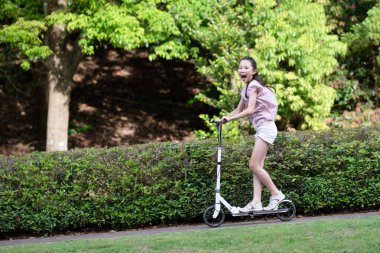 Tekme scooterda oynayan kız