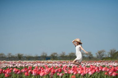 Çiçek bahçesinde oynayan kız.