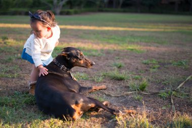 Parkta köpeği olan küçük kız.