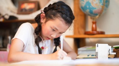 Evde ciddi ciddi çalışan bir kız.