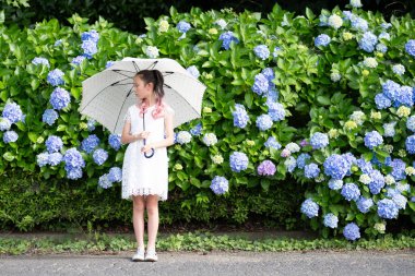 Ortancaların önünde şemsiyeli bir kız.