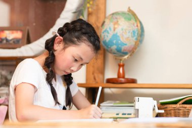 Evde ciddi ciddi çalışan bir kız.