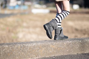 Çizme giyen bir çocuk yürüyor.