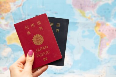 Japon pasaportu ve dünya haritasını elinde tutan bir kadın.