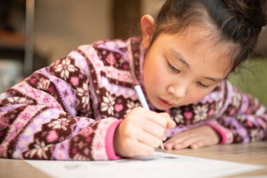 Evde ciddi ciddi çalışan bir kız.